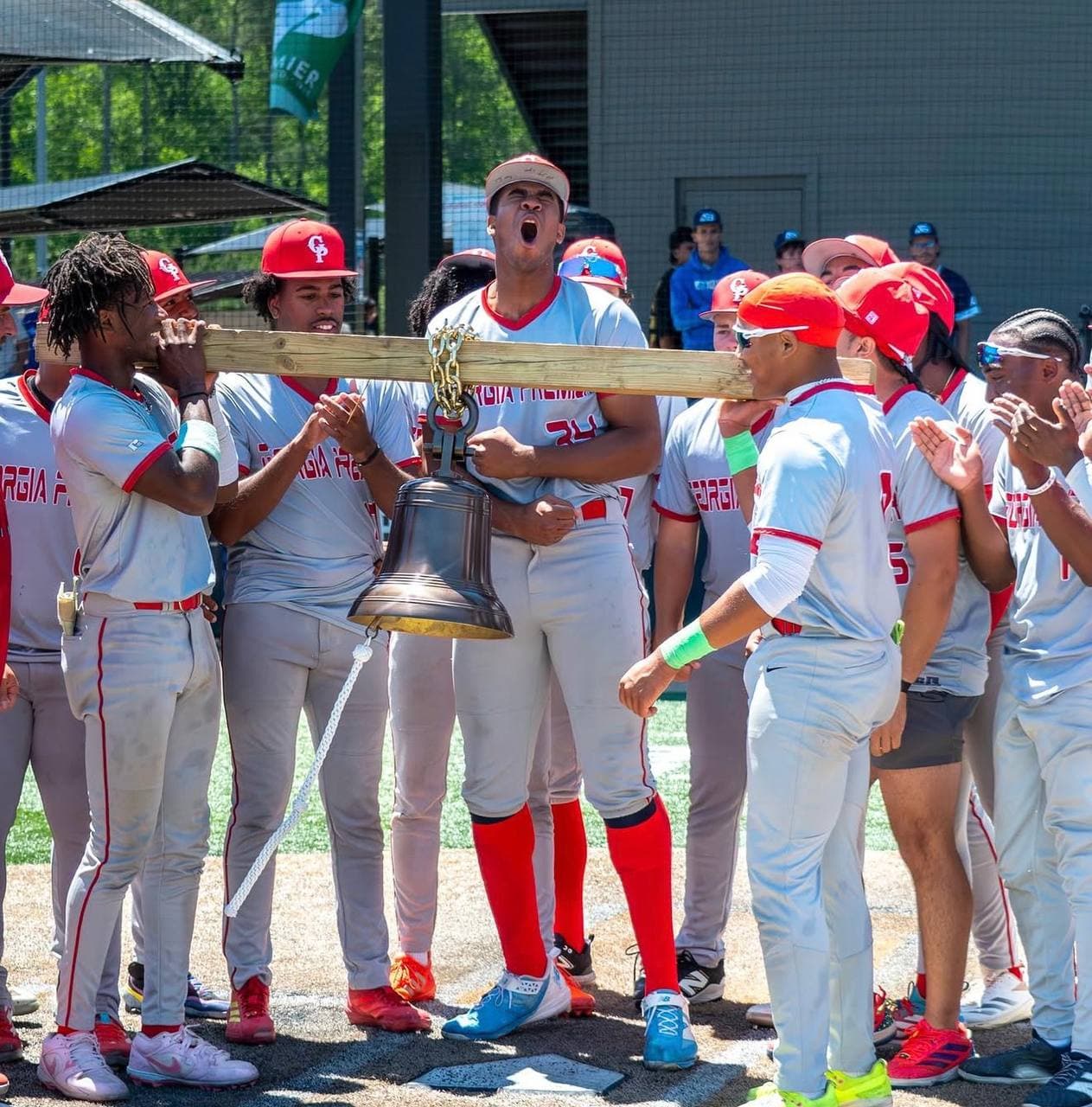 Georgia Premier players celebrate with the championship bell at home plate